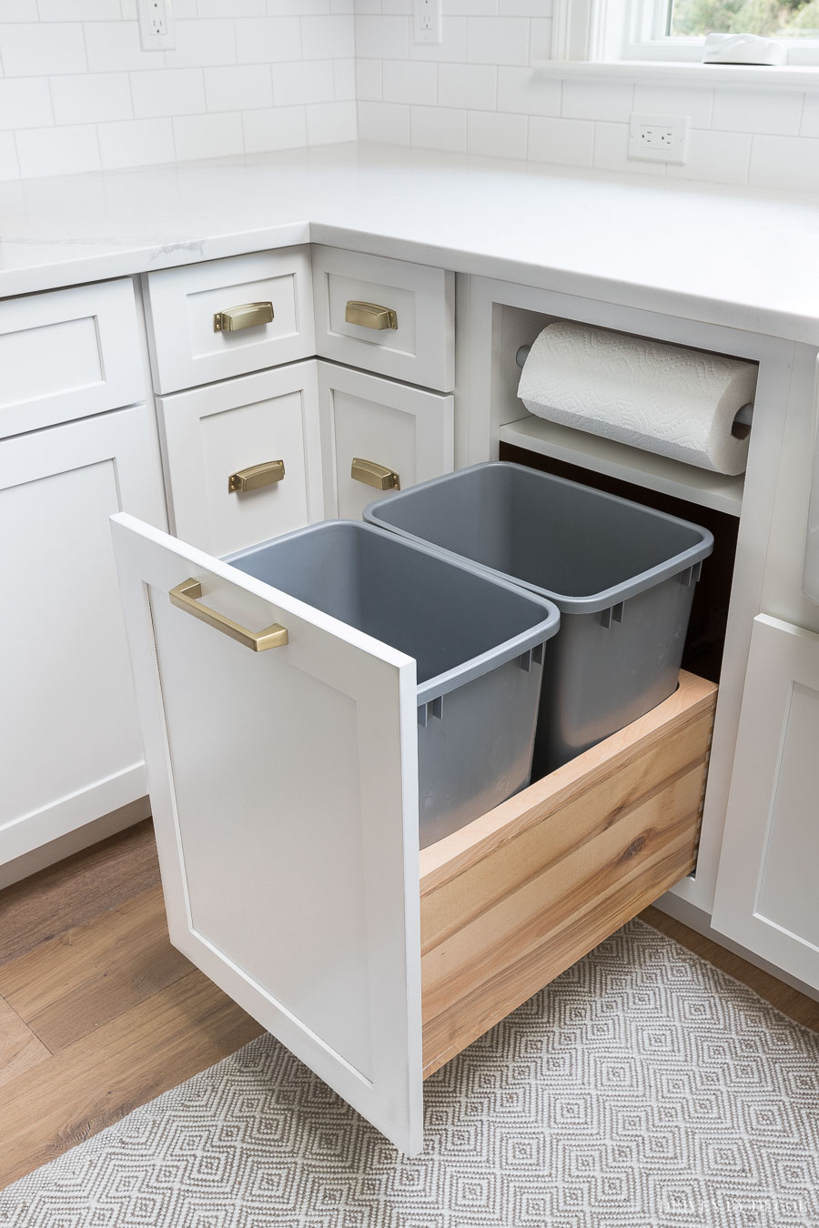 https://www.drivenbydecor.com/wp-content/uploads/2018/08/kitchen-garbage-pull-out-cabinet-built-in-paper-towel-holder-organization.jpg