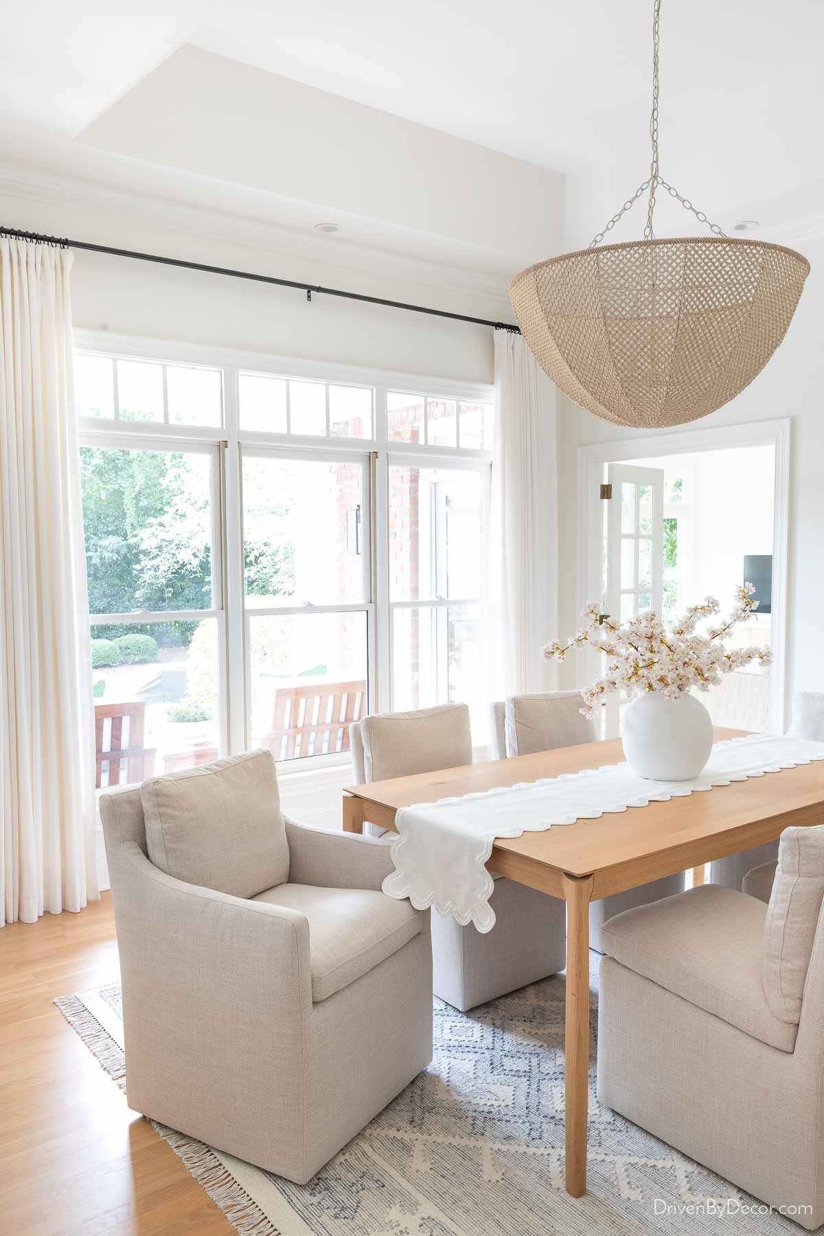 Dining room with flatweave blue and white rug and beaded chandelier